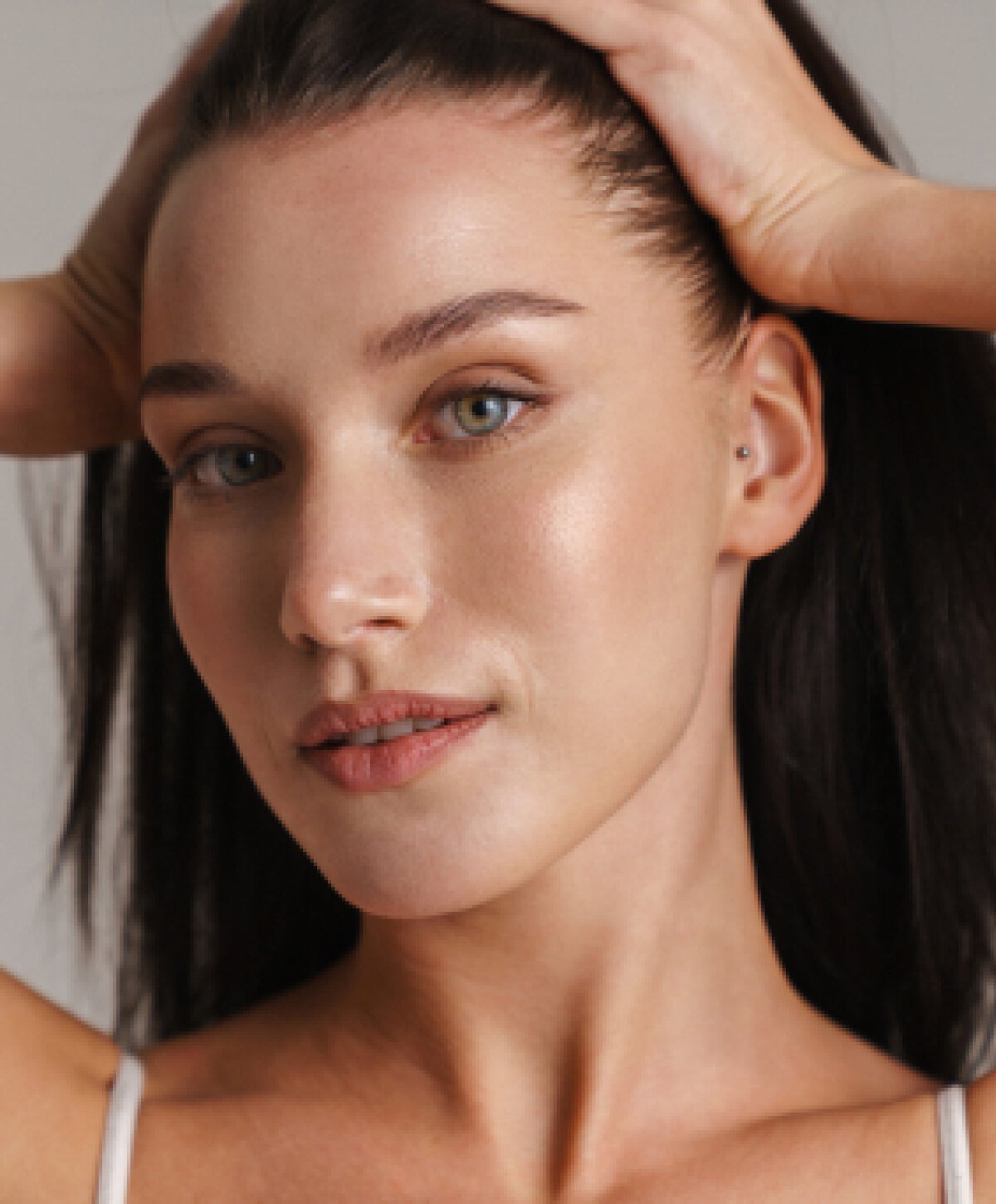 New Orleans otoplasty patient holding hair up